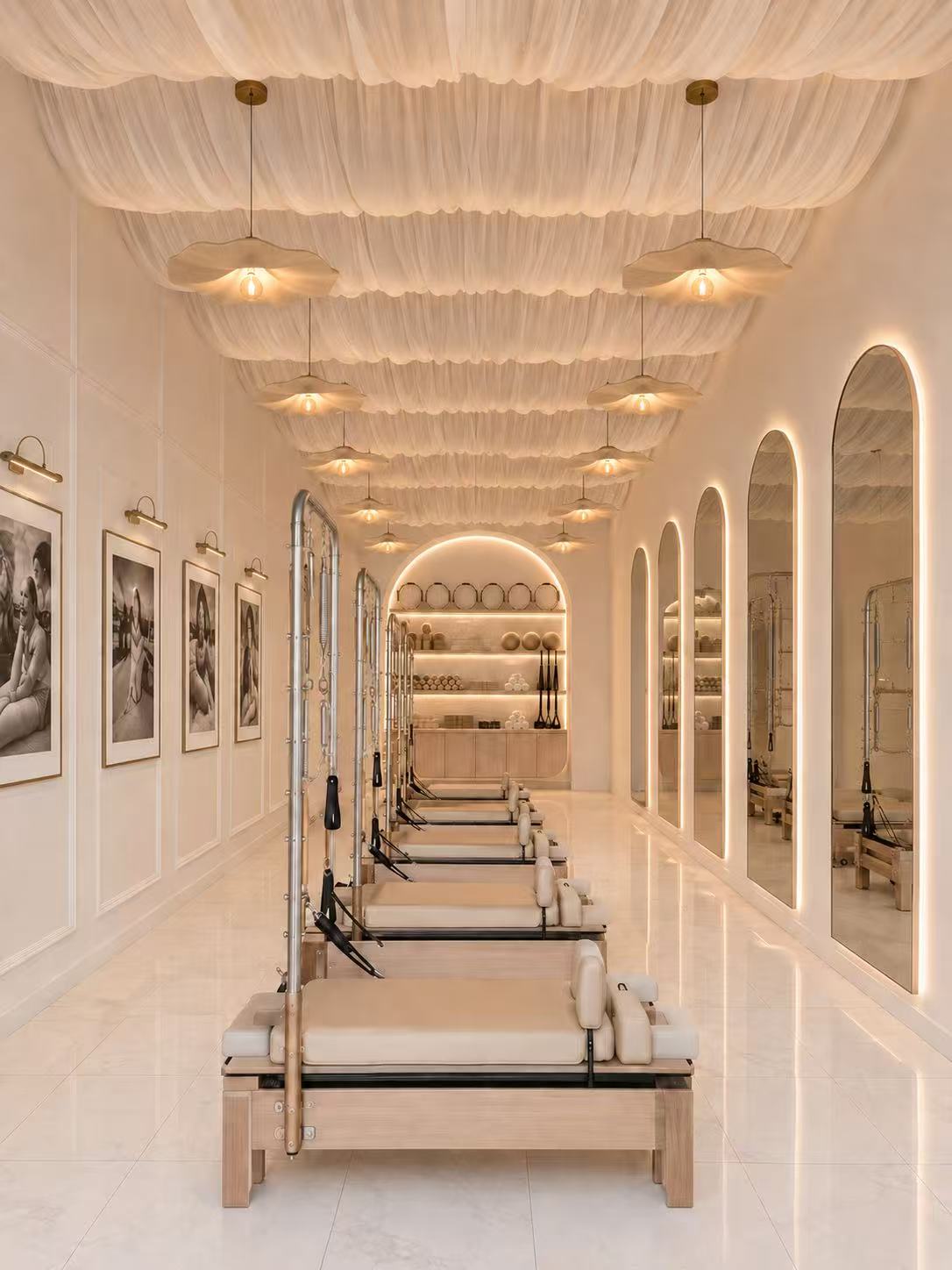 My Pilates Era reformer studio with draped ceilings and illuminated arched mirrors